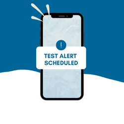  graphic of cell phone with alert symbol and text saying test alert scheduled